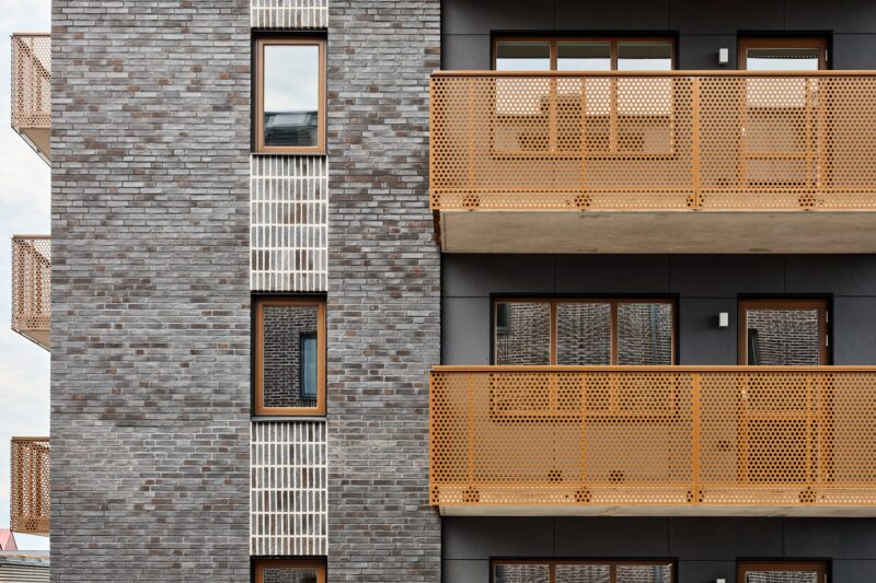 Detaljbild tegel och bruna balkonger Arkitekturfotografering av det nybyggda bostadsprojektet Ranalyckan, ett kvarter i stadsdelen Ranagård i Halmstad.