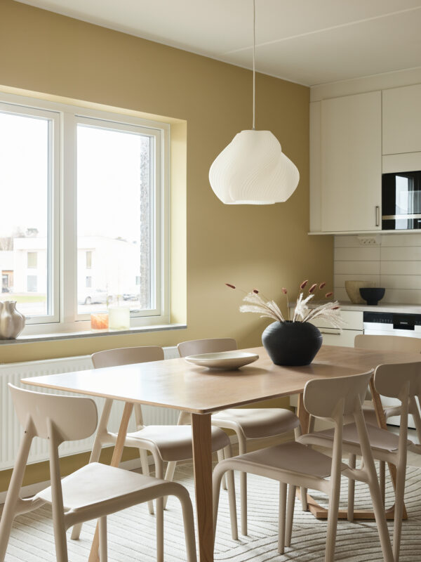 Kök med gula väggar. Interiörfotografering av visningslägenhet i det nybyggda bostadsprojektet Ranalyckan, ett kvarter i stadsdelen Ranagård i Halmstad för Skanska Bostad.