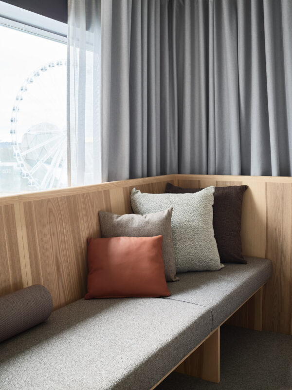 Hotellfoto Gothia Towers Wingårdhs Arkitekter Ljust trä sobra färger, detaljbild på kuddar i soffa med Liseberg i bakgrunden