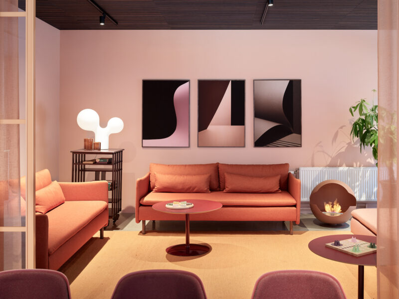 Interiörbild på soffa och brasa, rosa, beiga, orangea och bruna nyanser
